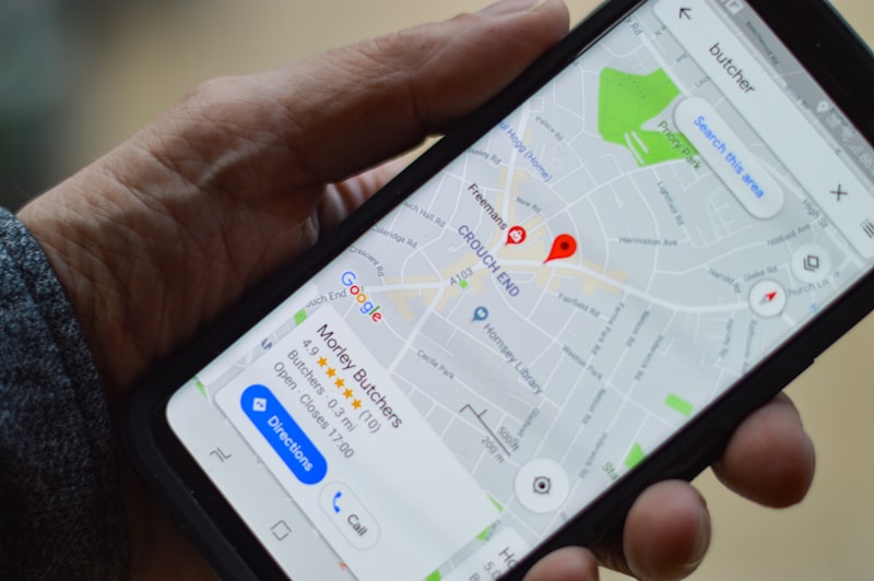 Main tenant un smartphone affichant la fiche Google d'un commerce sur Google Maps