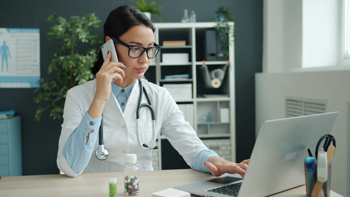 Médecin en blouse blanche qui téléphone devant son ordinateur portable dans son cabinet