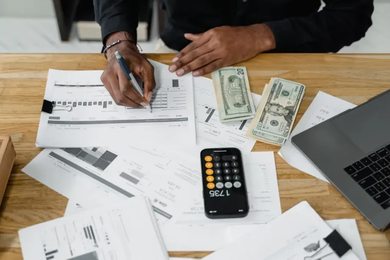 Entrepreneur comparant deux devis pour l'audit de sa fiche Google My Business avec une calculatrice